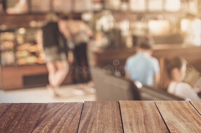 Tampo da mesa de madeira com a barra borrada da imagem na cafetaria fotografia de stock Tampo da mesa de madeira com a barra borrada da imagem na cafetaria fotografia de stock