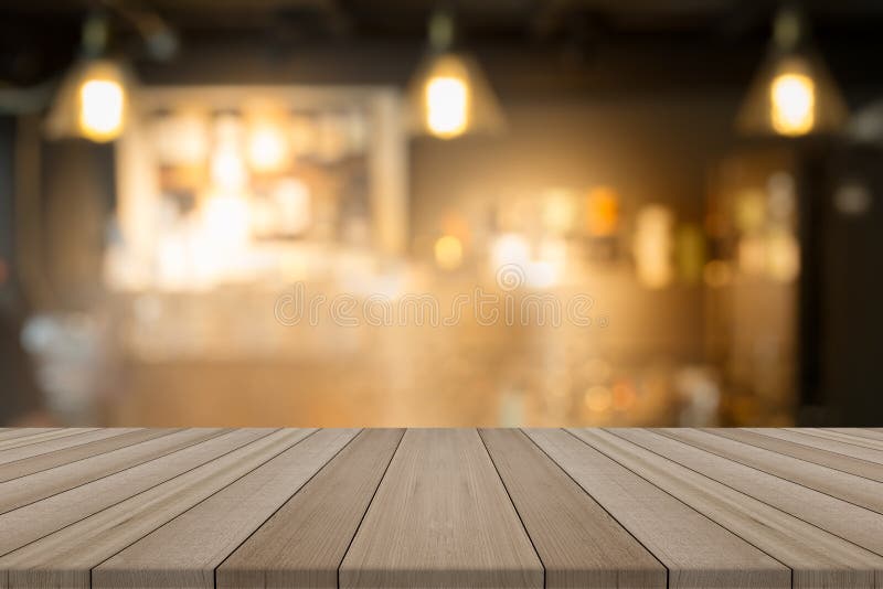 Tampo da mesa de madeira vazio na cafetaria borrada do formulário do fundo