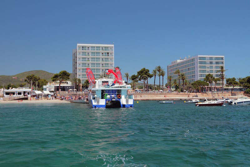 Tana Bossa, Ibiza, Spagna di Playa - 5 luglio 2017: Catamarano del partito della barca all'attracco del traghetto fotografia stock Tana Bossa, Ibiza, Spagna di Playa - 5 luglio 2017: Catamarano del partito della barca all'attracco del traghetto fotografia stock
