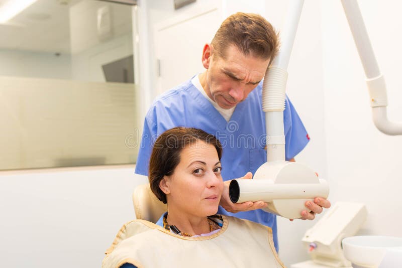 Tandarts die een tandenradiografie nemen aan een patiënt royalty-vrije stock foto's Tandarts die een tandenradiografie nemen aan een patiënt royalty-vrije stock foto's