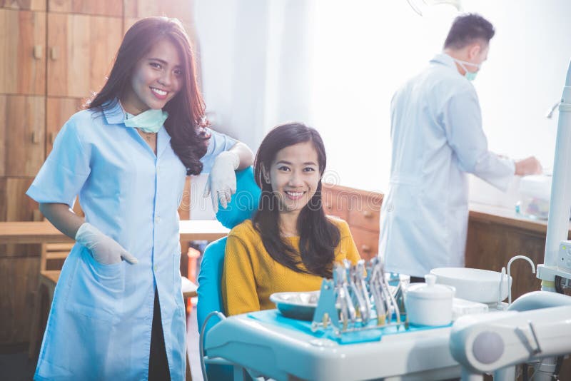 Tandarts die met vrouwelijke patiënt in tandkliniek glimlachen royalty-vrije stock afbeeldingen Tandarts die met vrouwelijke patiënt in tandkliniek glimlachen royalty-vrije stock afbeeldingen