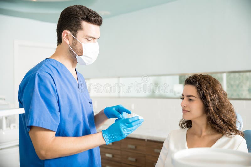 Tandarts Explaining Dental Mold aan Vrouw in Kliniek royalty-vrije stock afbeelding Tandarts Explaining Dental Mold aan Vrouw in Kliniek royalty-vrije stock afbeelding