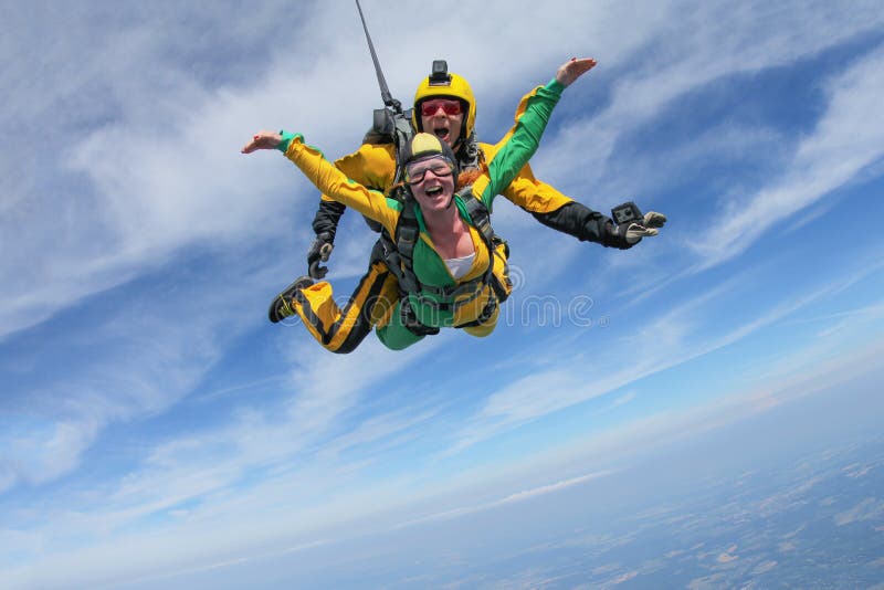 Tandemowy skydiving Aktywna dziewczyna lata w niebieskim niebie zdjęcia stock Tandemowy skydiving Aktywna dziewczyna lata w niebieskim niebie zdjęcia stock