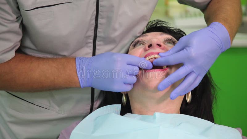 Tandläkare som behandlar tänder för patient` ett s med tand- hjälpmedel i tand- klinik dentistry