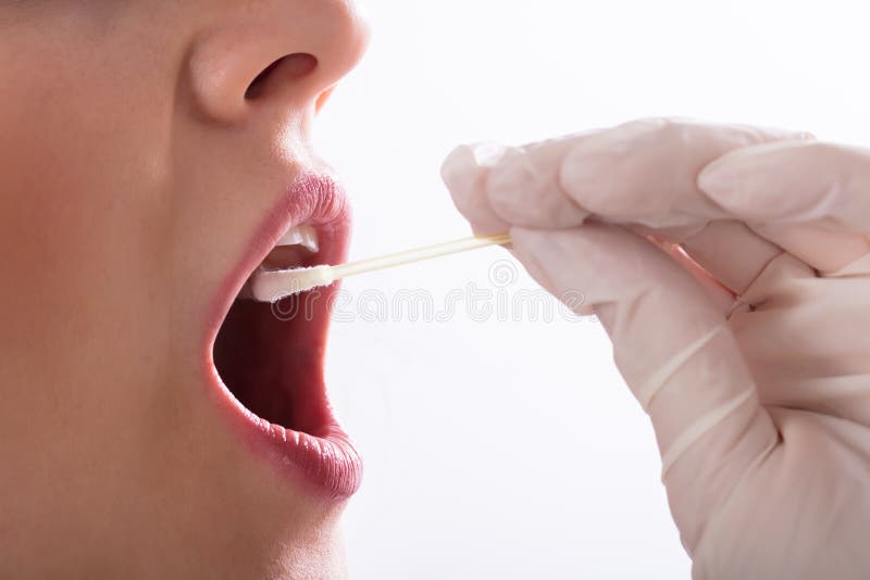 Tandläkare Taking Saliva Test av en patient fotografering för bildbyråer Tandläkare Taking Saliva Test av en patient fotografering för bildbyråer
