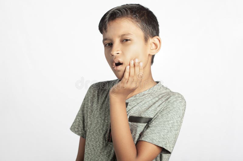 Tandsmärtor som en indiansk pojke lider av när han håller tandvärk arkivfoto