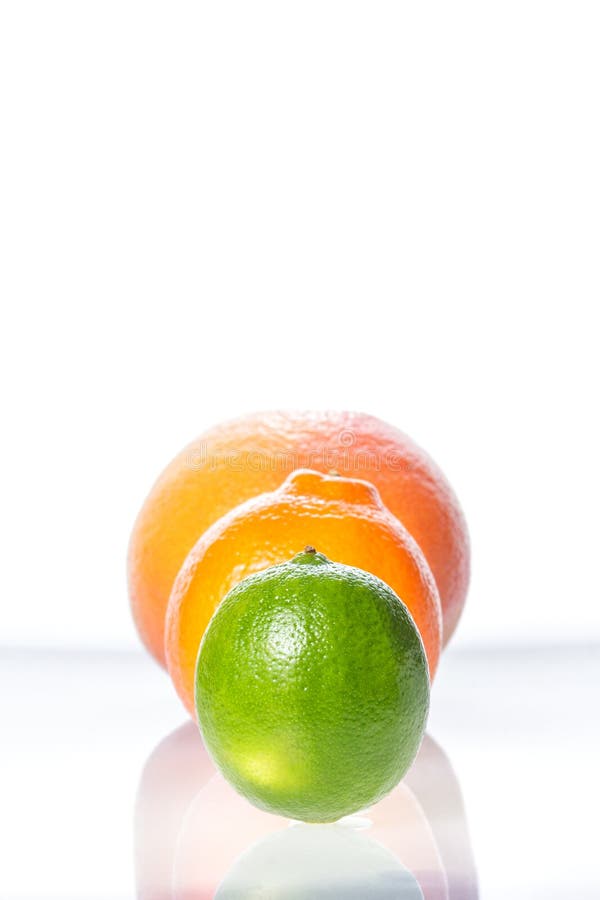 Tangerine, grapefruit and lime on black plate isolated on white