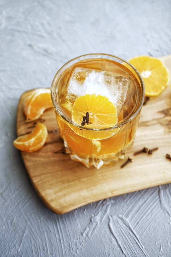 tangerine κοκτέιλ με τον πάγο σε ένα χαμηλό γυαλί highball και tangerine σε έναν ξύλινο πίνακα ελιών σε ένα γκρίζο κατασκευασμένο στοκ εικόνα με δικαίωμα ελεύθερης χρήσης tangerine κοκτέιλ με τον πάγο σε ένα χαμηλό γυαλί highball και tangerine σε έναν ξύλινο πίνακα ελιών σε ένα γκρίζο κατασκευασμένο στοκ εικόνα με δικαίωμα ελεύθερης χρήσης