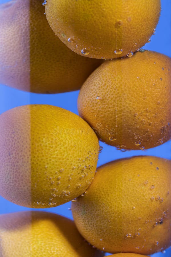 Tangerines in a Glass Glass with Water and Gas Bubbles Stock Photo