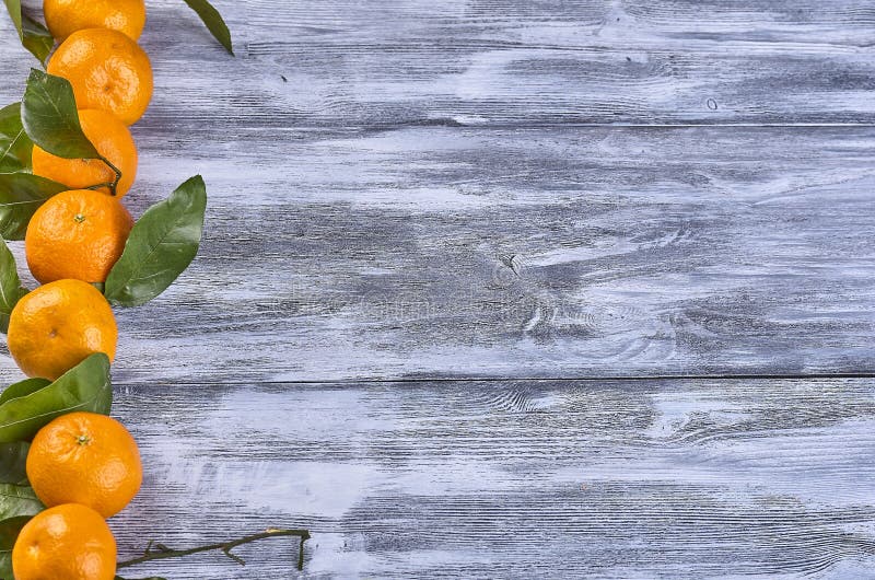 Tangerines with leaves on a wooden background