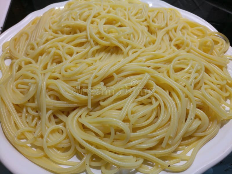 Tangled ha cucinato gli spaghetti su un piatto bianco immagine stock libera da diritti Tangled ha cucinato gli spaghetti su un piatto bianco immagine stock libera da diritti