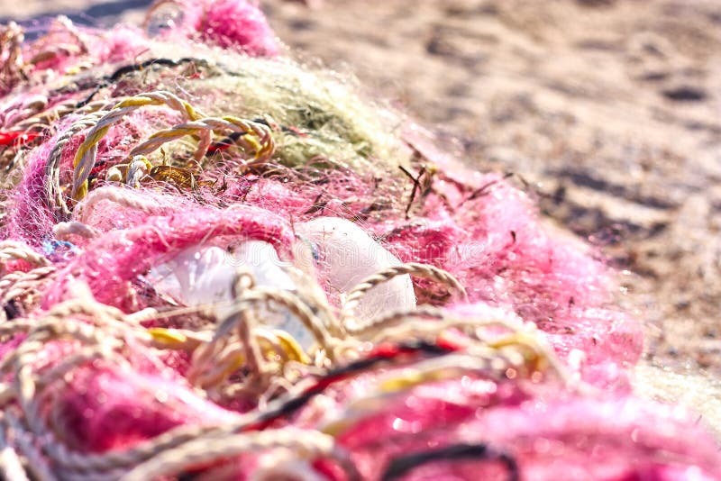 A tangled mess of fishing nets plastic rope and other debris washed up on a coastal beach