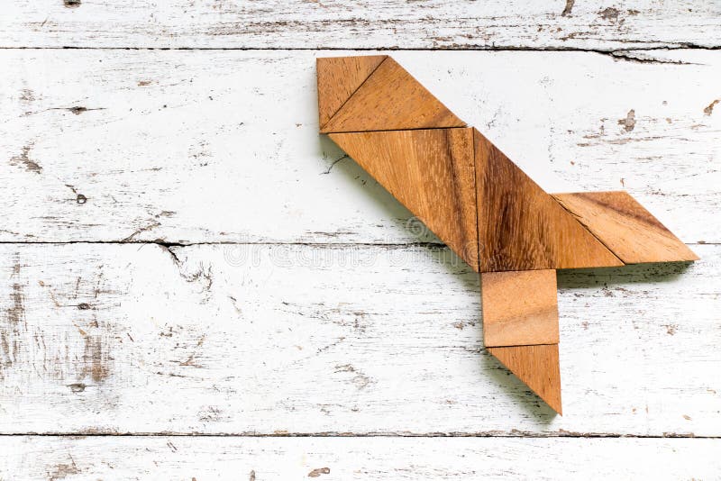 Tangram puzzle in missile or rocket shape on white wood background royalty free stock photos