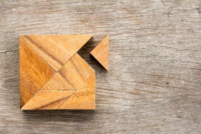 Tangram puzzle with one piece is wait to match the square shape on wood background Concept for love fulfillment
