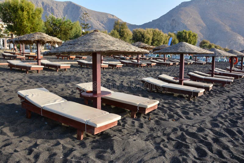 Tanning Beds and Umbrellas on Perissa Beach, Santorini, Greece Stock