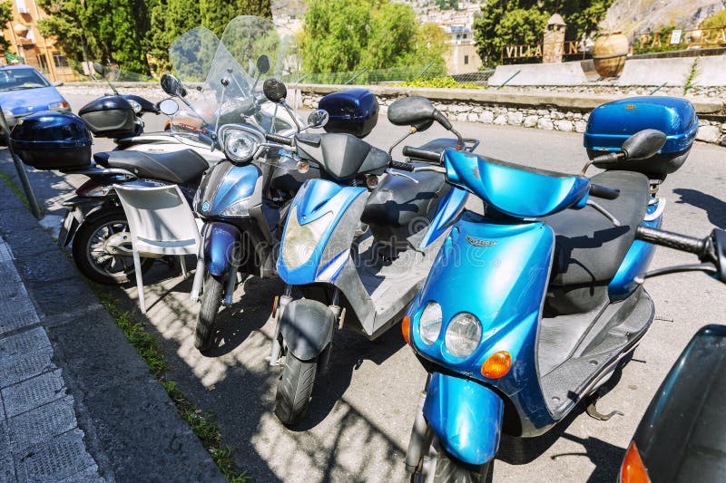 Taormina, Italy, 08/30/2016: Parking scooters on a city street royalty free stock image Taormina, Italy, 08/30/2016: Parking scooters on a city street royalty free stock image