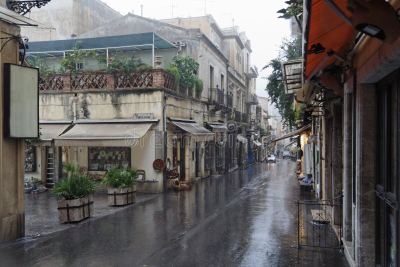 The narrow streets of the city of Taormina with its stores and medieval buildings under the rain. Sicily island, Italy. The narrow streets of the city of Taormina with its stores and medieval buildings under the rain. Sicily island, Italy.