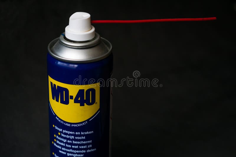Tapa de aerosolum WD-40 sobre fondo negro, imagen editorial ilustrativa