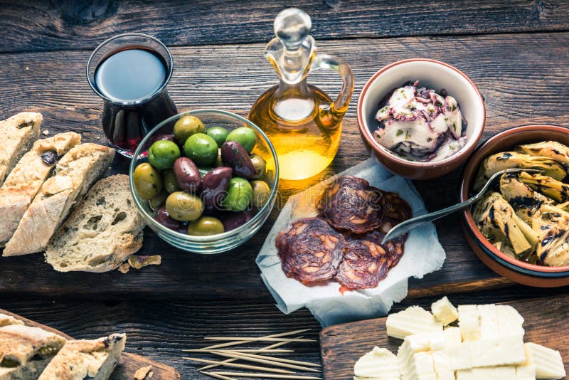 Traditional Spanish tapas served on a rustic wooden table with red wine