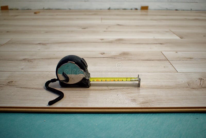 The Tape Measure Lies on the Laminate. the Process of Laying Laminate Flooring Stock Photo