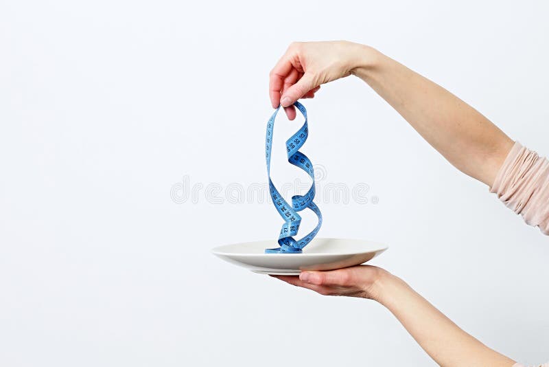 Tape measure spaghetti on the plate representing slimming and weight loss