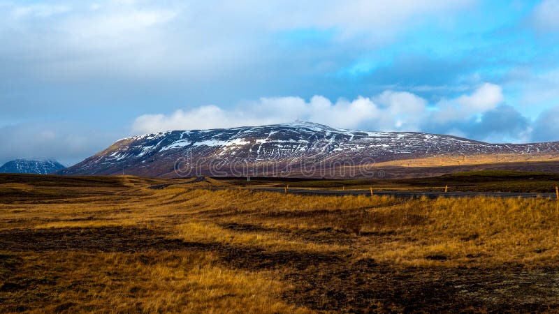 Tapetowy widok łąki i śnieżny wzgórze w Iceland fotografia stock Tapetowy widok łąki i śnieżny wzgórze w Iceland fotografia stock