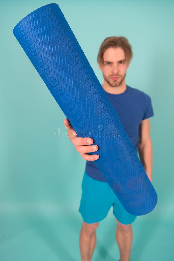 Tapis de yoga ou de pilates à disposition d'homme de tache floue Tapis bleu roulé à disposition Équipement de gymnase pour la for photos stock Tapis de yoga ou de pilates à disposition d'homme de tache floue Tapis bleu roulé à disposition Équipement de gymnase pour la for photos stock