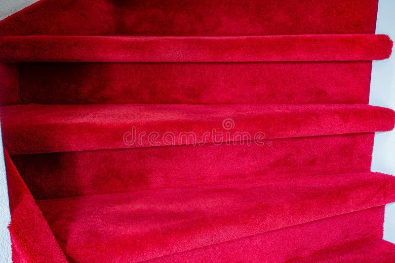 Tappeto rosso su scale di legno bianco in una casa, lusso all'aria, un interno moderno immagine stock Tappeto rosso su scale di legno bianco in una casa, lusso all'aria, un interno moderno immagine stock