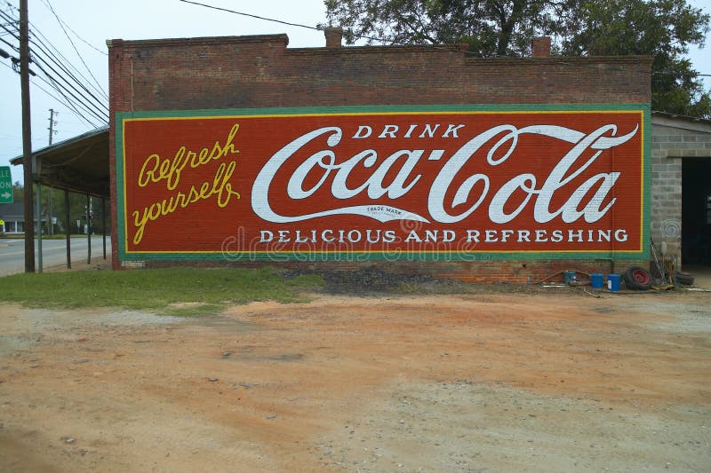 Tappningcoca - colaannonseringtecknet målade på sida av gammal byggnad i slättar, Georgia royaltyfri fotografi
