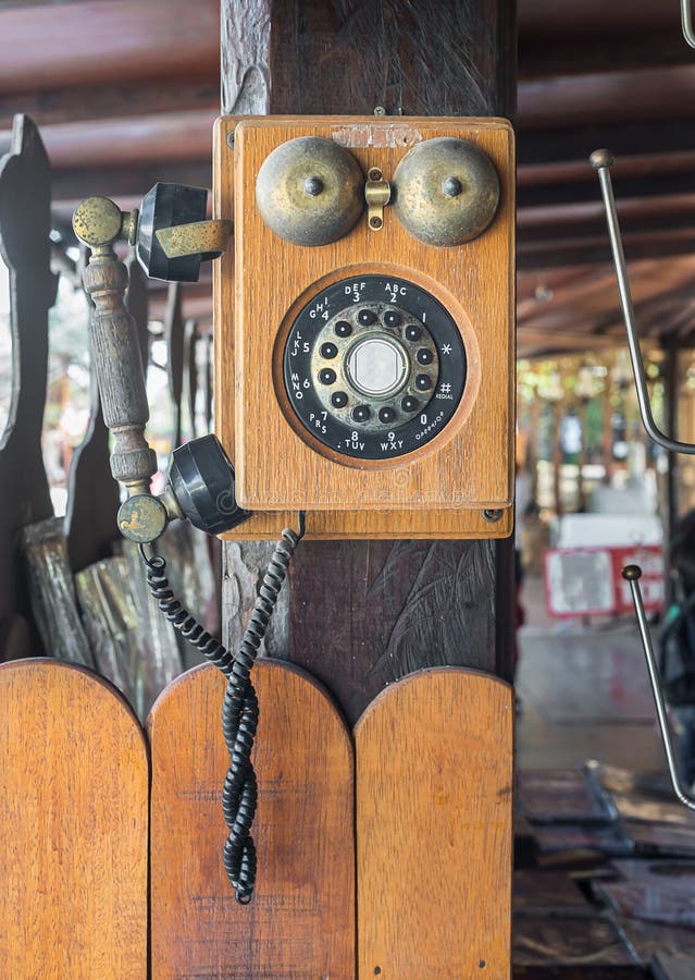 Tappningtelefonhängning på träpol royaltyfri bild Tappningtelefonhängning på träpol royaltyfri bild