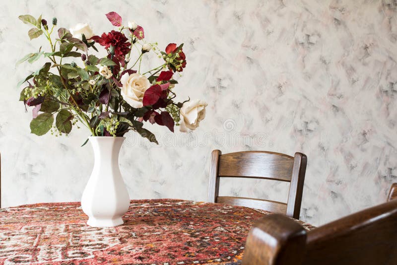 Tappningvardagsrum med den runda äta middag tabellen med blommor och modellen tapetserar royaltyfria bilder Tappningvardagsrum med den runda äta middag tabellen med blommor och modellen tapetserar royaltyfria bilder