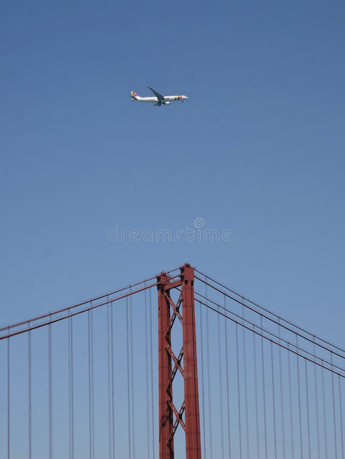 Lisbon, Portugal - May 20, 2023: Airplane of TAP Air Portugal, the flag carrier of Portugal, flying over the famous suspension bridge in Lisbon. Lisbon, Portugal - May 20, 2023: Airplane of TAP Air Portugal, the flag carrier of Portugal, flying over the famous suspension bridge in Lisbon