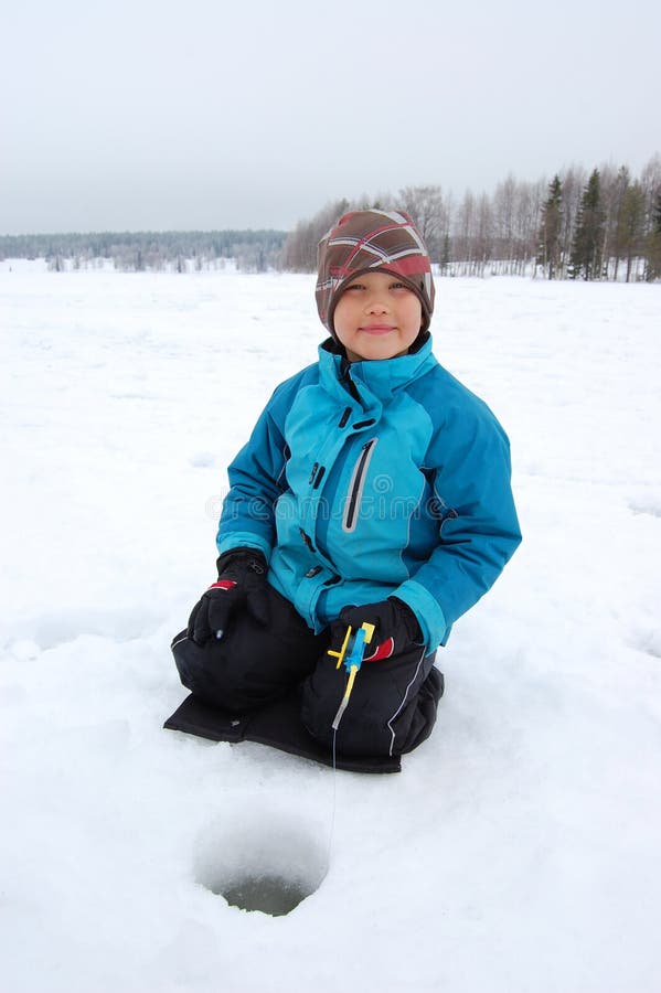 Boy ice fishing on lake in winter. Boy ice fishing on lake in winter