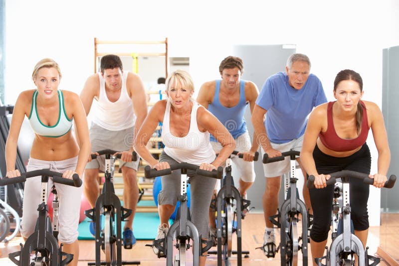 Group Of People In Spinning Class In Gym. Group Of People In Spinning Class In Gym