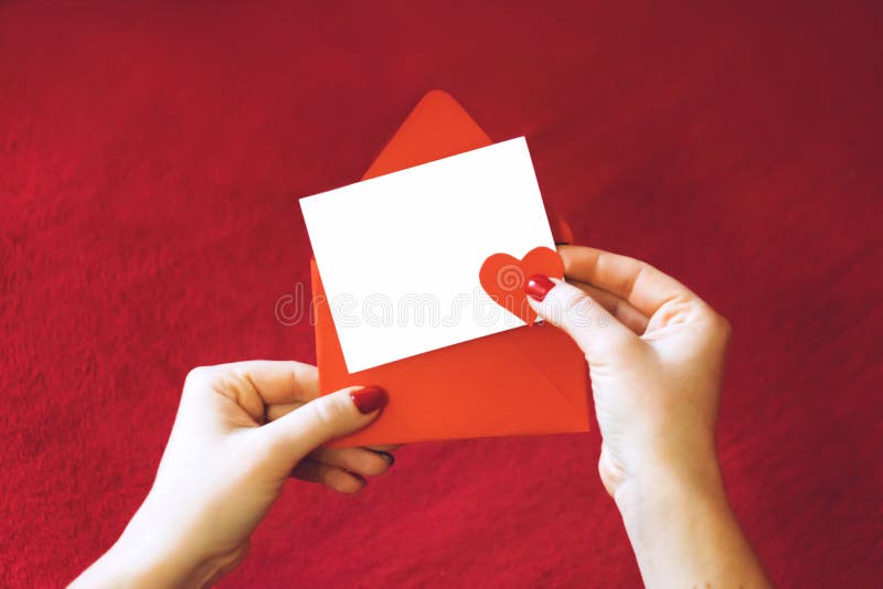 Tarjeta de felicitación de día de San Valentín, maqueta con el espacio de la copia Mano femenina con la tarjeta vacía y sobre roj fotografía de archivo libre de regalías Tarjeta de felicitación de día de San Valentín, maqueta con el espacio de la copia Mano femenina con la tarjeta vacía y sobre roj fotografía de archivo libre de regalías