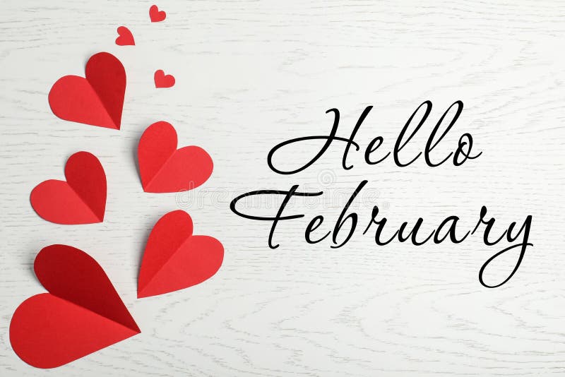 Tarjeta de saludo con texto Hola febrero Coros de papel rojo sobre fondo de madera blanca, tendido plano