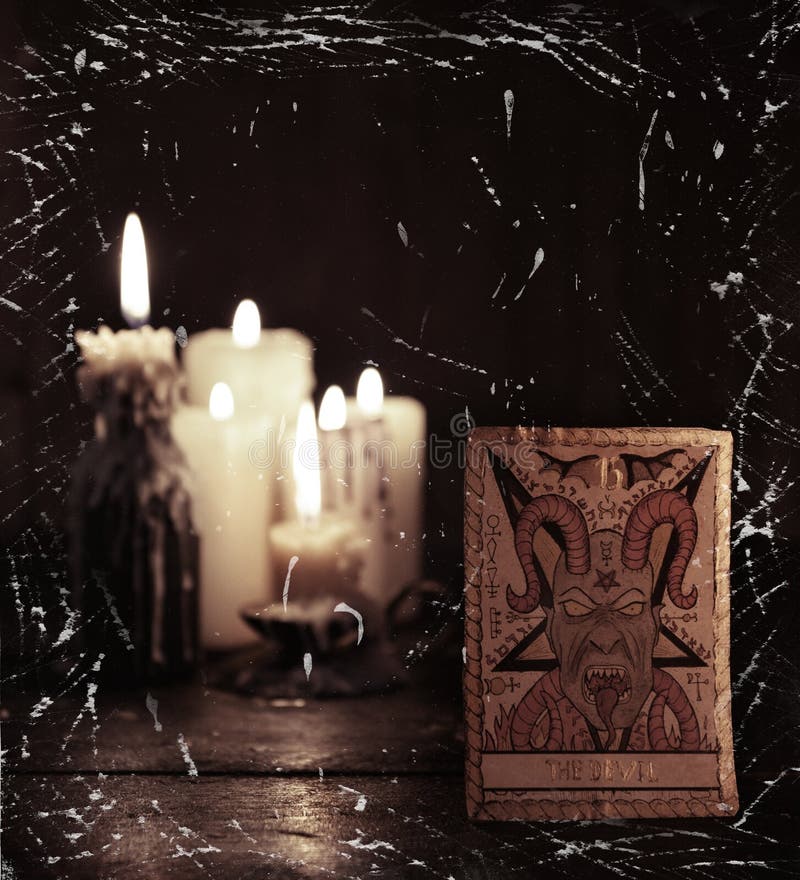 The tarot card with Devil against defocused candles background stock photo The tarot card with Devil against defocused candles background stock photo