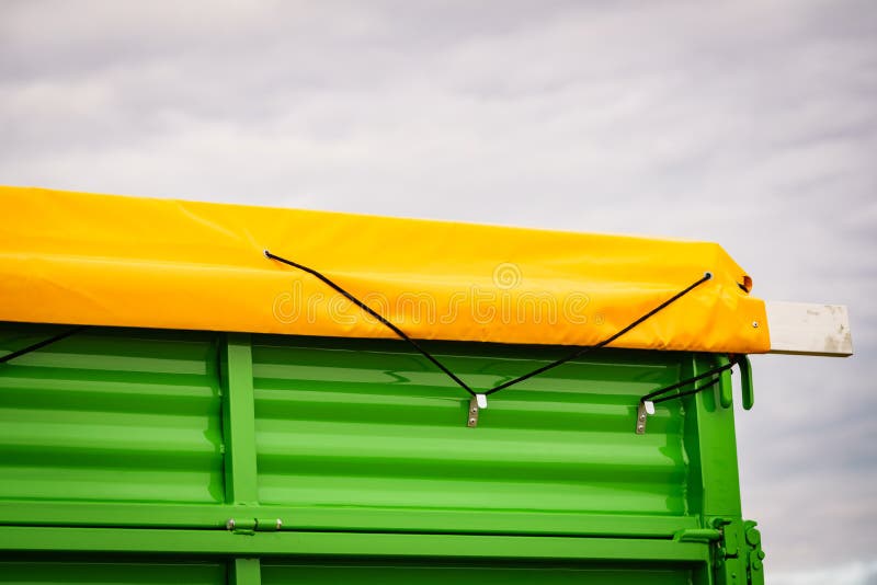 Yellow tarp tarpaulin fastened with rope to trailer. Yellow tarp tarpaulin fastened with rope to trailer