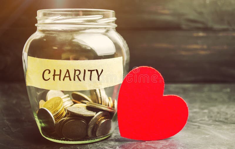 Tarro de cristal con la caridad de las palabras y el corazón El concepto de acumular el dinero para las donaciones ahorro Ayuda m
