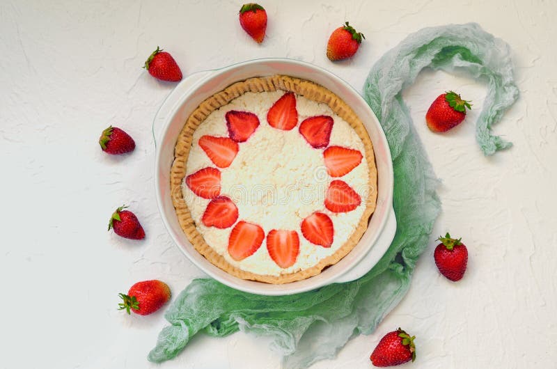 Tarta cruda de la fresa en el fondo blanco de la cocina Pastel de queso de las bayas adornado con las fresas y la menta frescas o imagen de archivo libre de regalías Tarta cruda de la fresa en el fondo blanco de la cocina Pastel de queso de las bayas adornado con las fresas y la menta frescas o imagen de archivo libre de regalías
