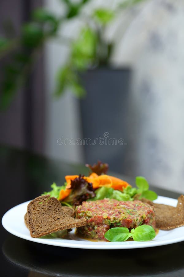 Tartar de carne cruda para gourmets. tartar de carne cruda con cubos de especias y hierbas. fotos de archivo libres de regalías
