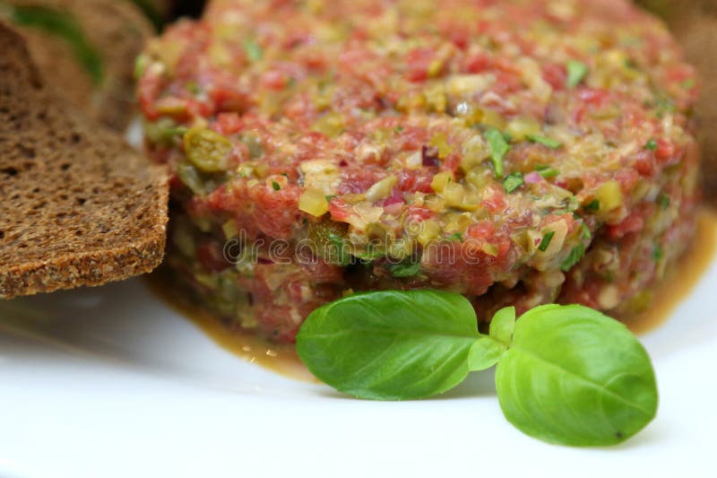Tartar de carne cruda para gourmets. tartar de carne cruda con cubos de especias y hierbas. foto de archivo libre de regalías