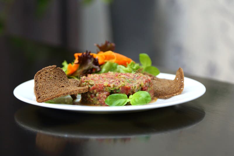 Tartar de carne cruda para gourmets. tartar de carne cruda con cubos de especias y hierbas. tartar de carne de vacuno con alcaparr fotos de archivo libres de regalías