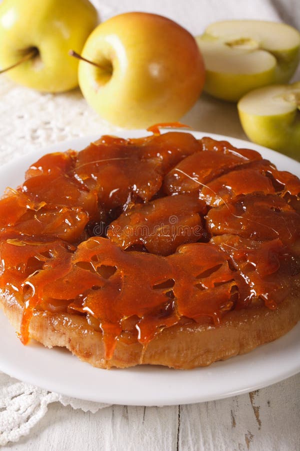 Tarte Tatin met appelen en karamel dichte omhooggaand op een plaat Vertica royalty-vrije stock afbeelding Tarte Tatin met appelen en karamel dichte omhooggaand op een plaat Vertica royalty-vrije stock afbeelding
