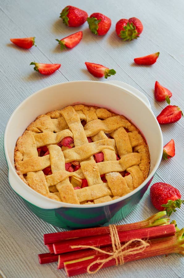 Tarte traditionnel de fraise de rhubarbe dans le plat de cuisson sur la table de cuisine grise Tarte de Veggie décorée des fraise image libre de droits Tarte traditionnel de fraise de rhubarbe dans le plat de cuisson sur la table de cuisine grise Tarte de Veggie décorée des fraise image libre de droits