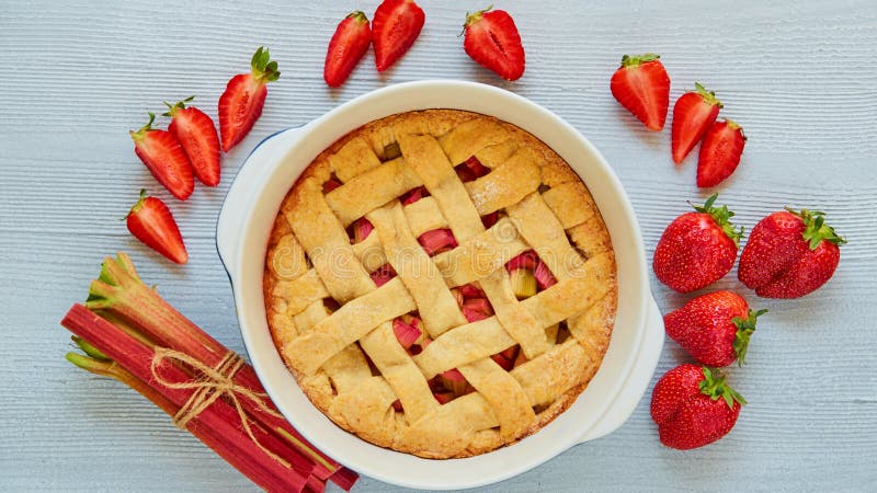 Tarte traditionnel de fraise de rhubarbe dans le plat de cuisson sur la table de cuisine grise Tarte végétarienne décorée des fra image stock Tarte traditionnel de fraise de rhubarbe dans le plat de cuisson sur la table de cuisine grise Tarte végétarienne décorée des fra image stock
