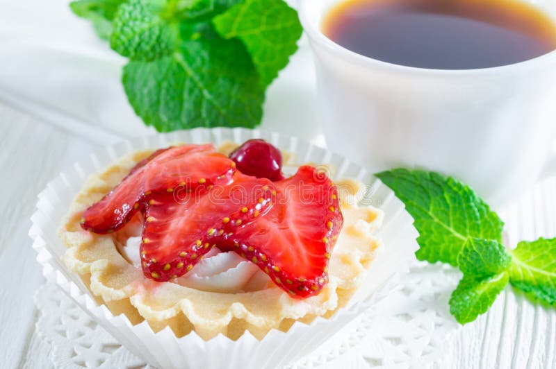 Tartlet ou bolo com morango e queijo creme frescos no fundo de madeira branco imagem de stock royalty free Tartlet ou bolo com morango e queijo creme frescos no fundo de madeira branco imagem de stock royalty free