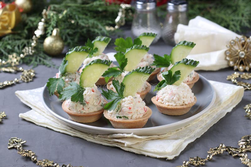 Tartlets With Crab Sticks Eggs Cheese And Cucumber On A Plate On Blue