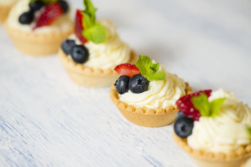 Tartlets med gräddost och jordgubbar arkivfoton Tartlets med gräddost och jordgubbar arkivfoton
