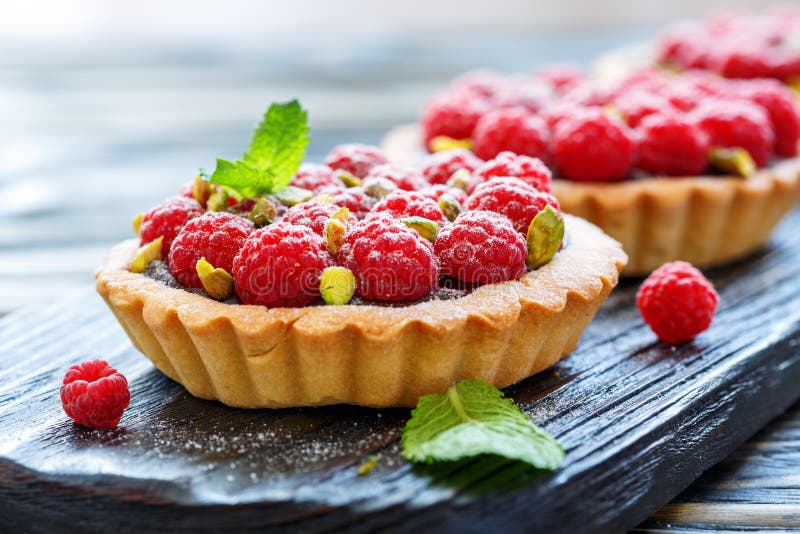 Tartlets mit frischen Himbeeren und Pistazien stockbild Tartlets mit frischen Himbeeren und Pistazien stockbild